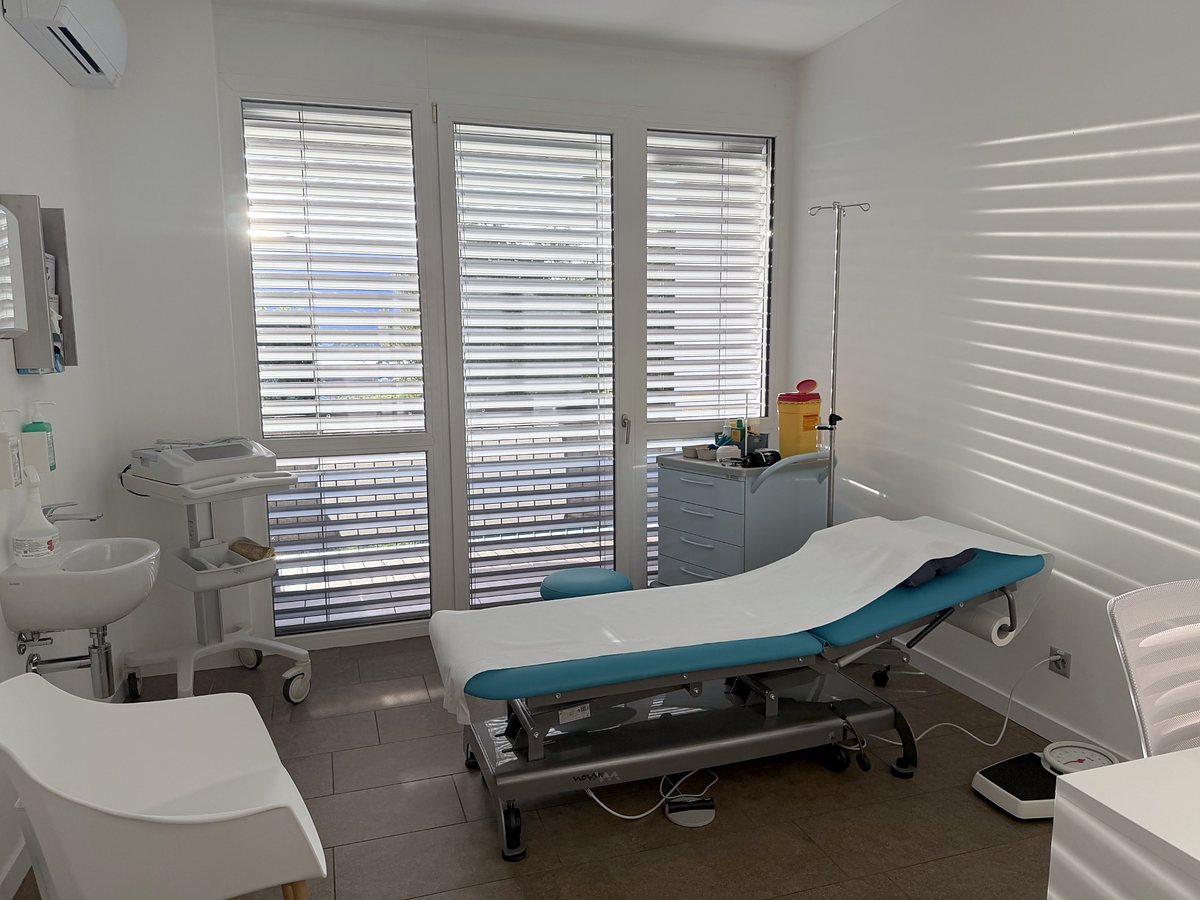 La sala visita 1 con il lettino, l'elettrocardiografo e il lavabo